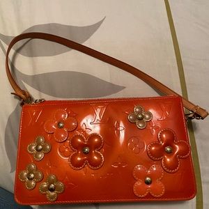 100% Authentic Louis Vuitton orange Vernis wristlet with flowers.